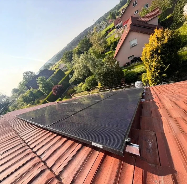 Installation de panneaux solaires photovoltaïques sur toiture résidentielle en tuiles rouges