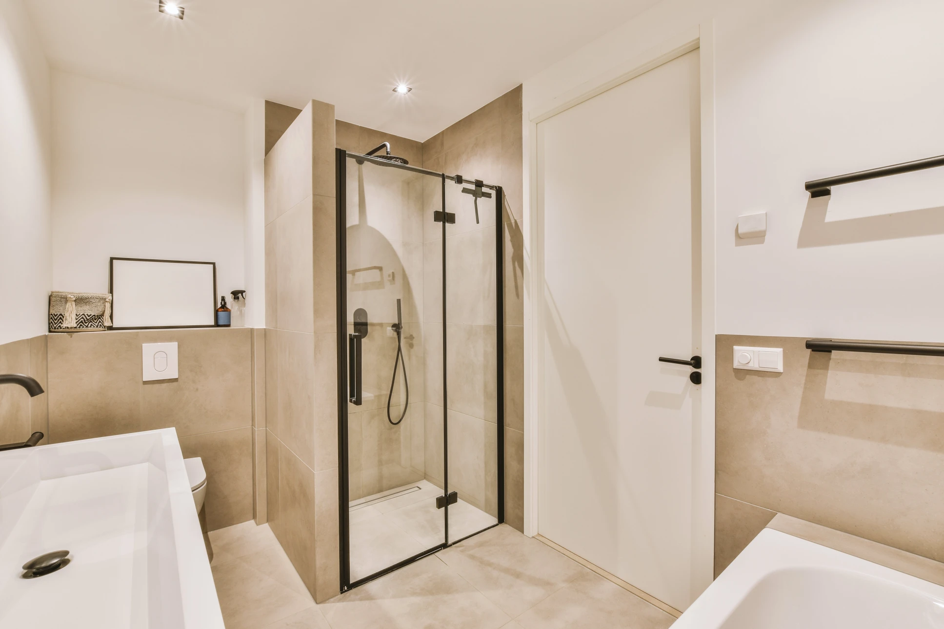 Int&eacute;rieur de salle de bain avec carrelage bleu, main actionnant la chasse d'eau d'un WC blanc