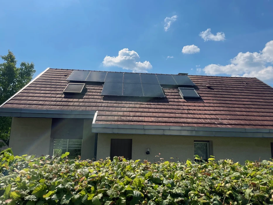 Maison moderne avec toiture en tuiles équipée de panneaux solaires photovoltaïques installés sur versant principal