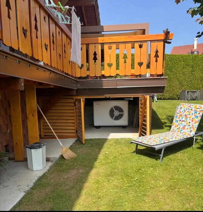 Extérieur d'un bâtiment résidentiel en brique rouge avec unité de climatisation installée sur le toit plat