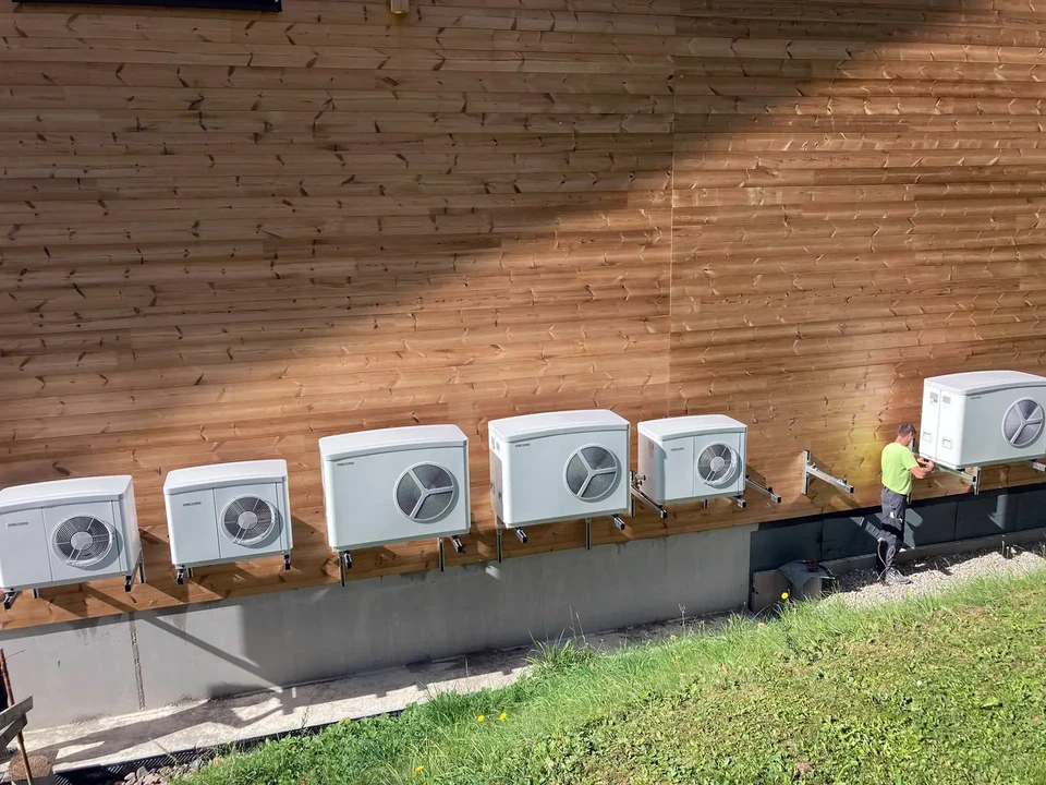 Technicien en gants installant un conduit de ventilation flexible métallisé dans un environnement intérieur