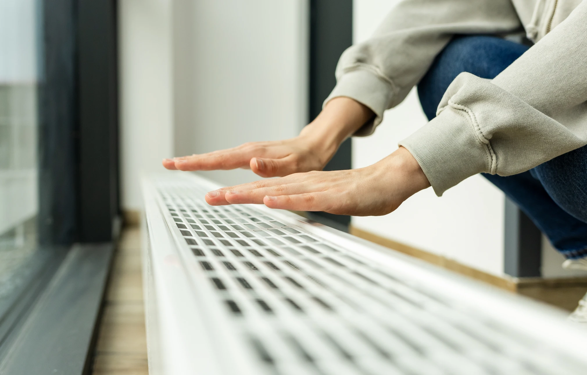 Plombier en combinaison grise et gants de protection blancs effectue la mesure d'installation sanitaire dans toilettes résidentielles